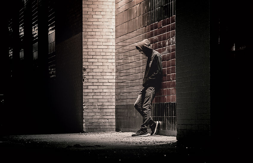 a depressed teenager in a street corner